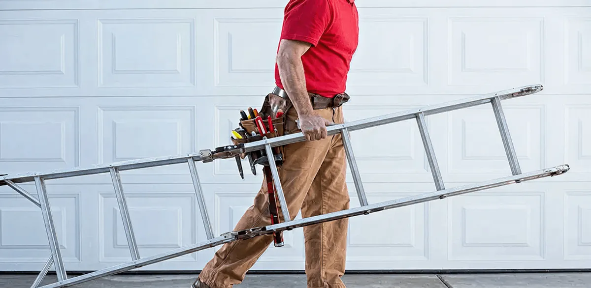 Garage door repair technician arriving with tools and ladder in Bloomington, IN