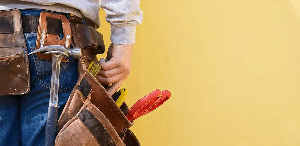 Handyman with tool belt ready for home repairs and maintenance in Bloomington, IN