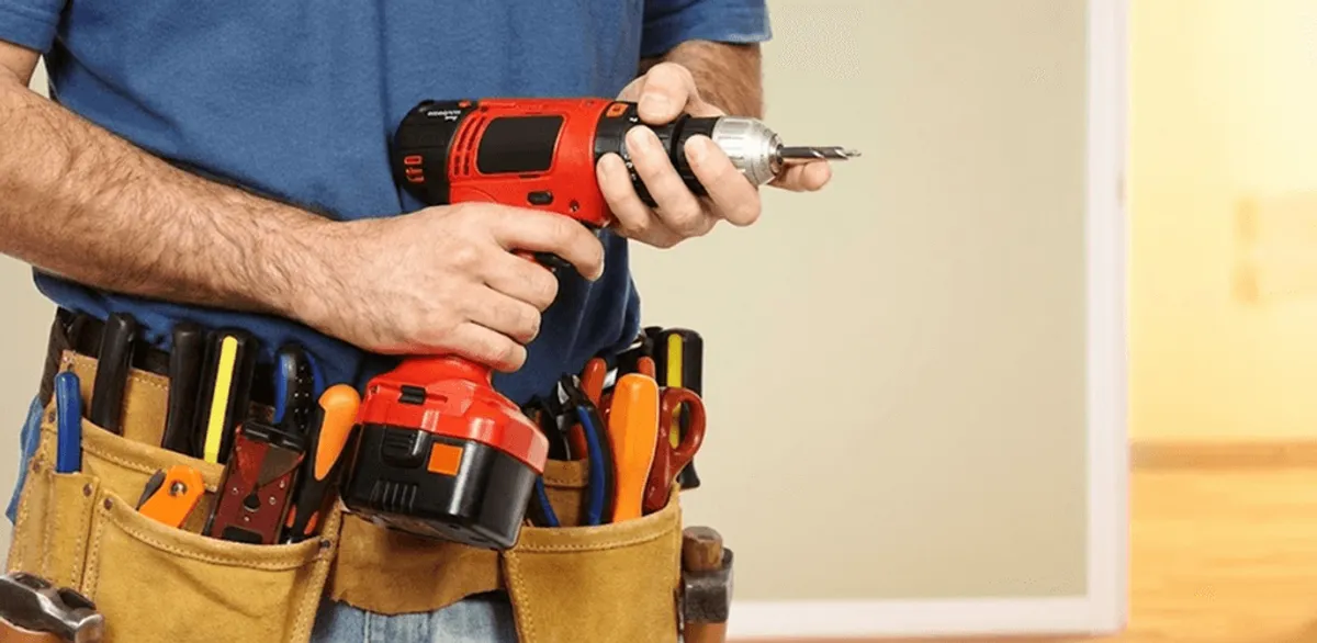 Handyman holding a power drill for home repairs and installations in Bloomington, IN