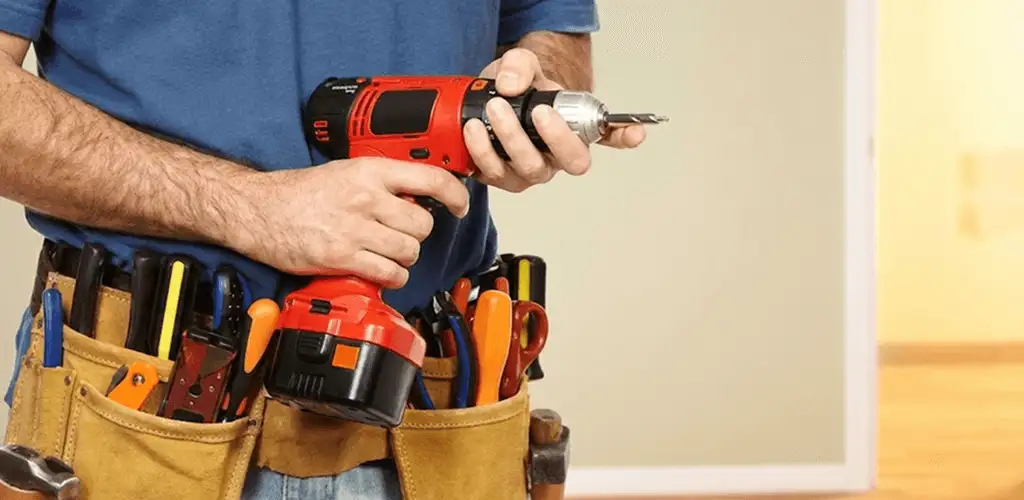 Handyman holding a power drill for home repairs and installations in Bloomington, IN