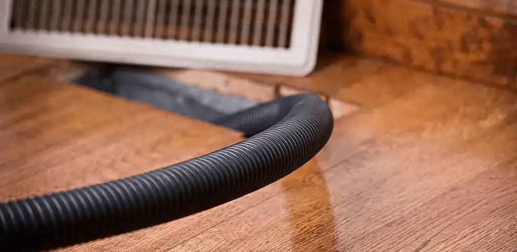 Air duct cleaning hose inserted into a floor vent for ductwork cleaning in Bloomington, IN