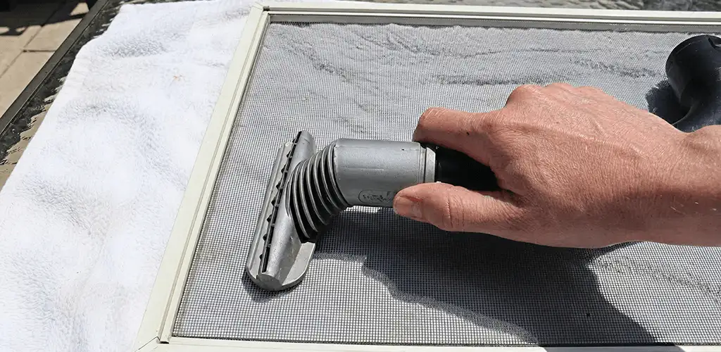 Window screen repair cleaning and fixing a damaged screen mesh in Bloomington, IN